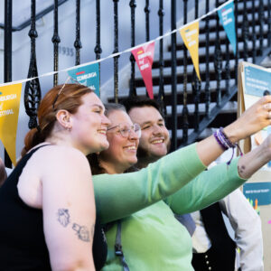 A group of people standing in front of a staircase taking a selfie.