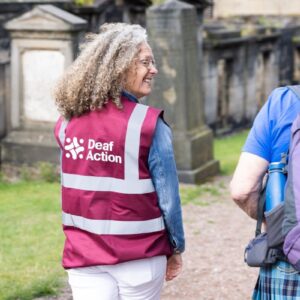 A tour guide wearing a Deaf Action vest.