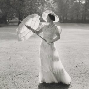 Black and white photo of the queen mother dressed in white holding a white umberella.