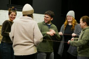 A group of people standing laughing with one another.