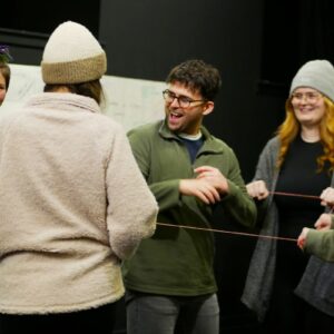 A group of people standing laughing with one another.