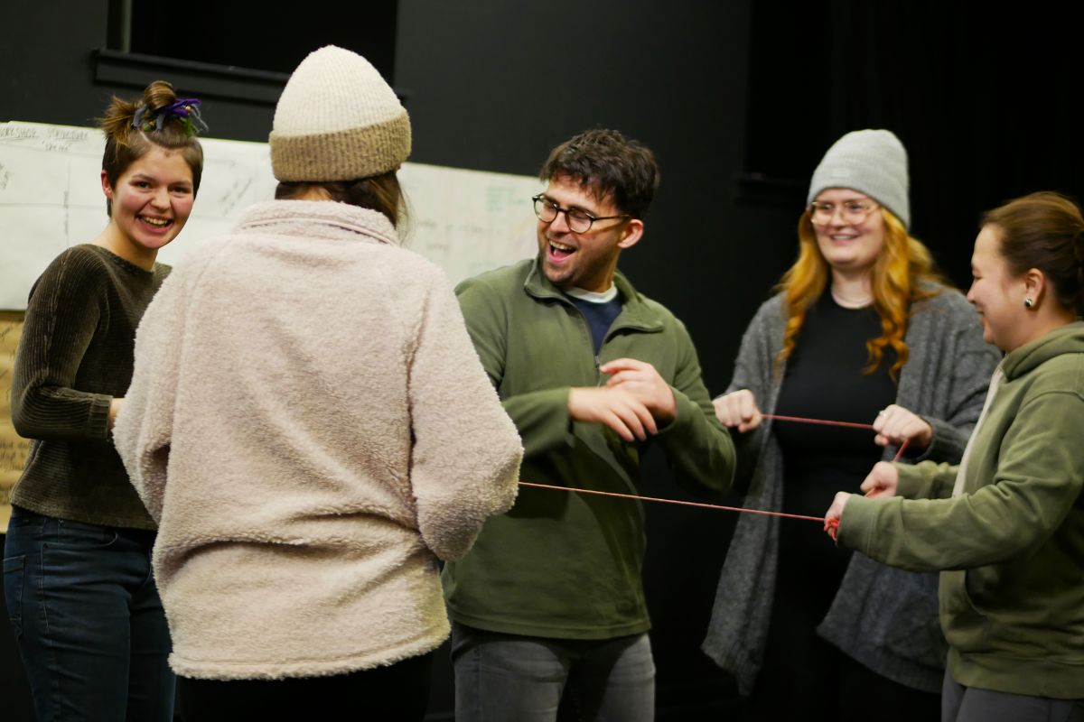 A group of people standing laughing with one another.